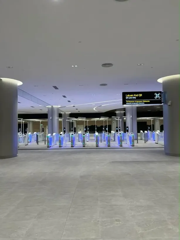The Laluan Kod QR — QR Lane Only sign above the Malaysia immigration clearance lanes