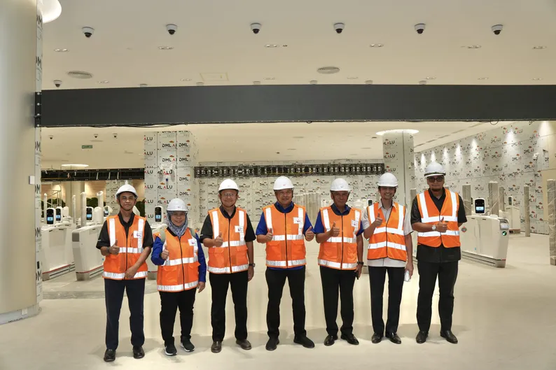 The visiting delegation and site teams lined up in front of the immigration autogates in the ICQ Complex hall