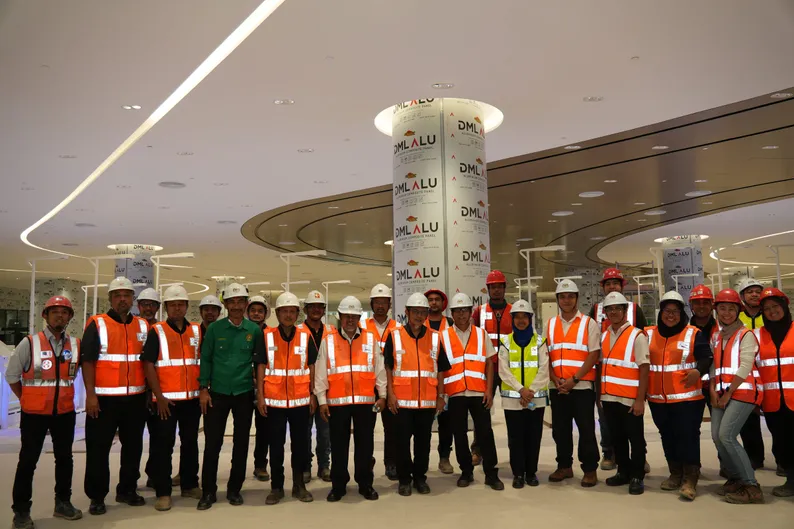 The visiting party and site teams assembled beneath the station hall’s clad columns