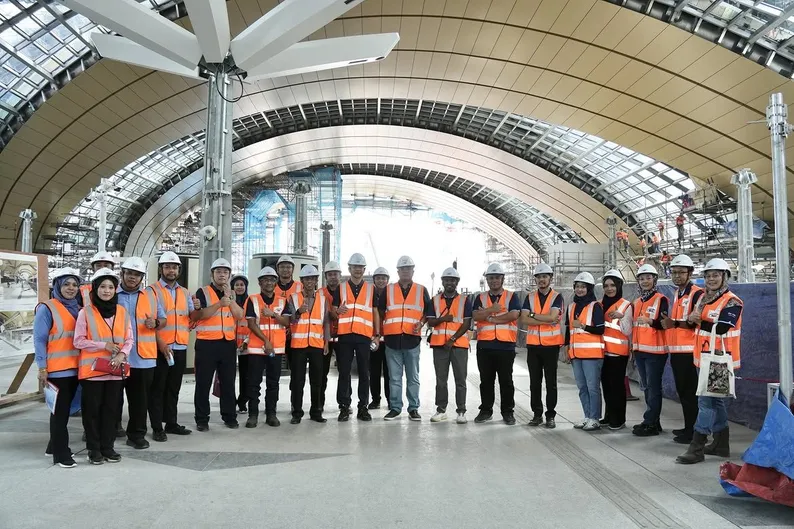 The delegation gathered under the station’s arched roof canopy during the site tour